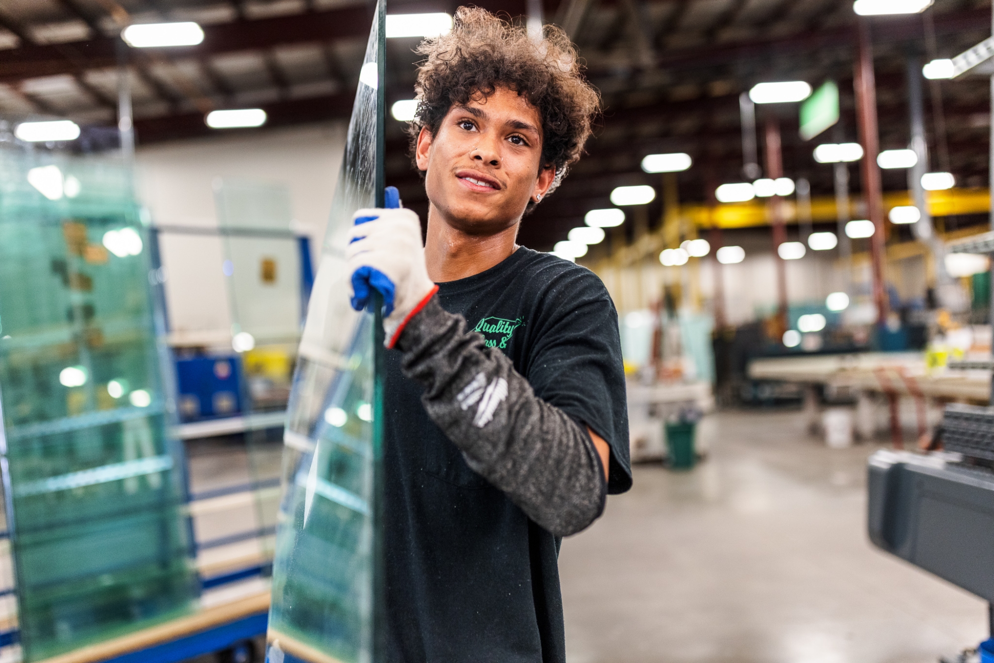 Quality Glass & Mirror employee carrying sheet of glass