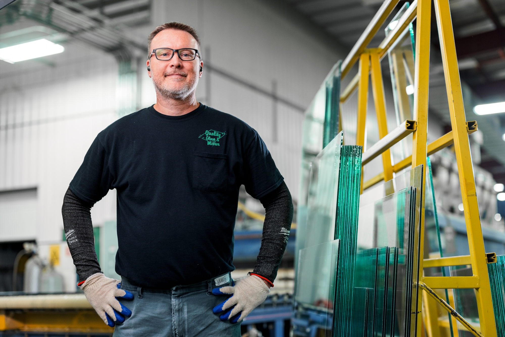Quality Glass & Mirror employee posing in front of glass