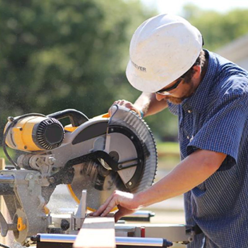 construction worker sawing wood