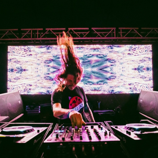 dj playing heavy bass music with big visual screen