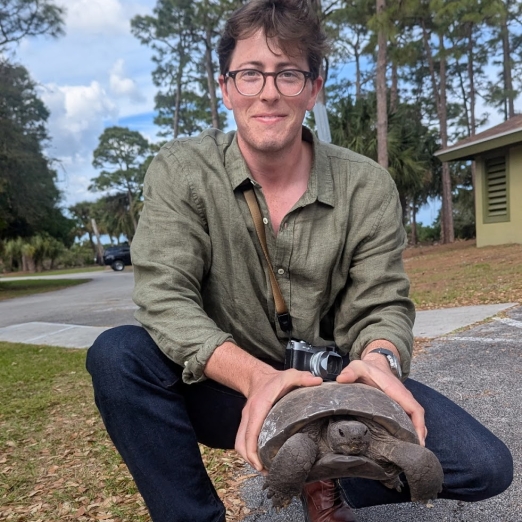 unanimous designer bryce keck holding a turtle